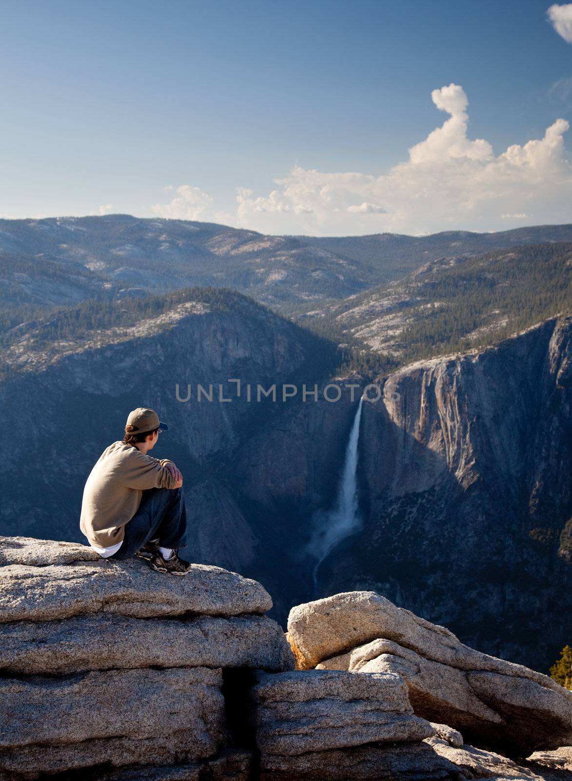 Young hiker overlooking Yosemite falls by steheap