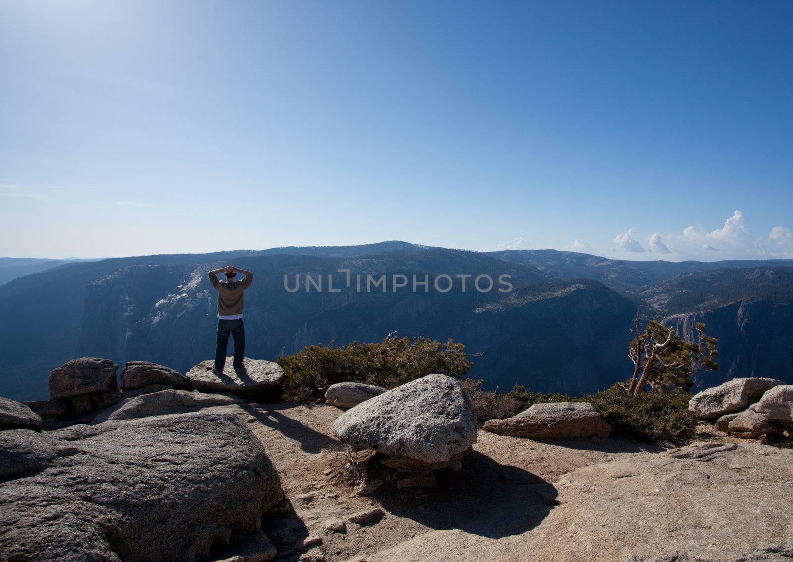 Male hiker looking at view from Yosemite Peak by steheap