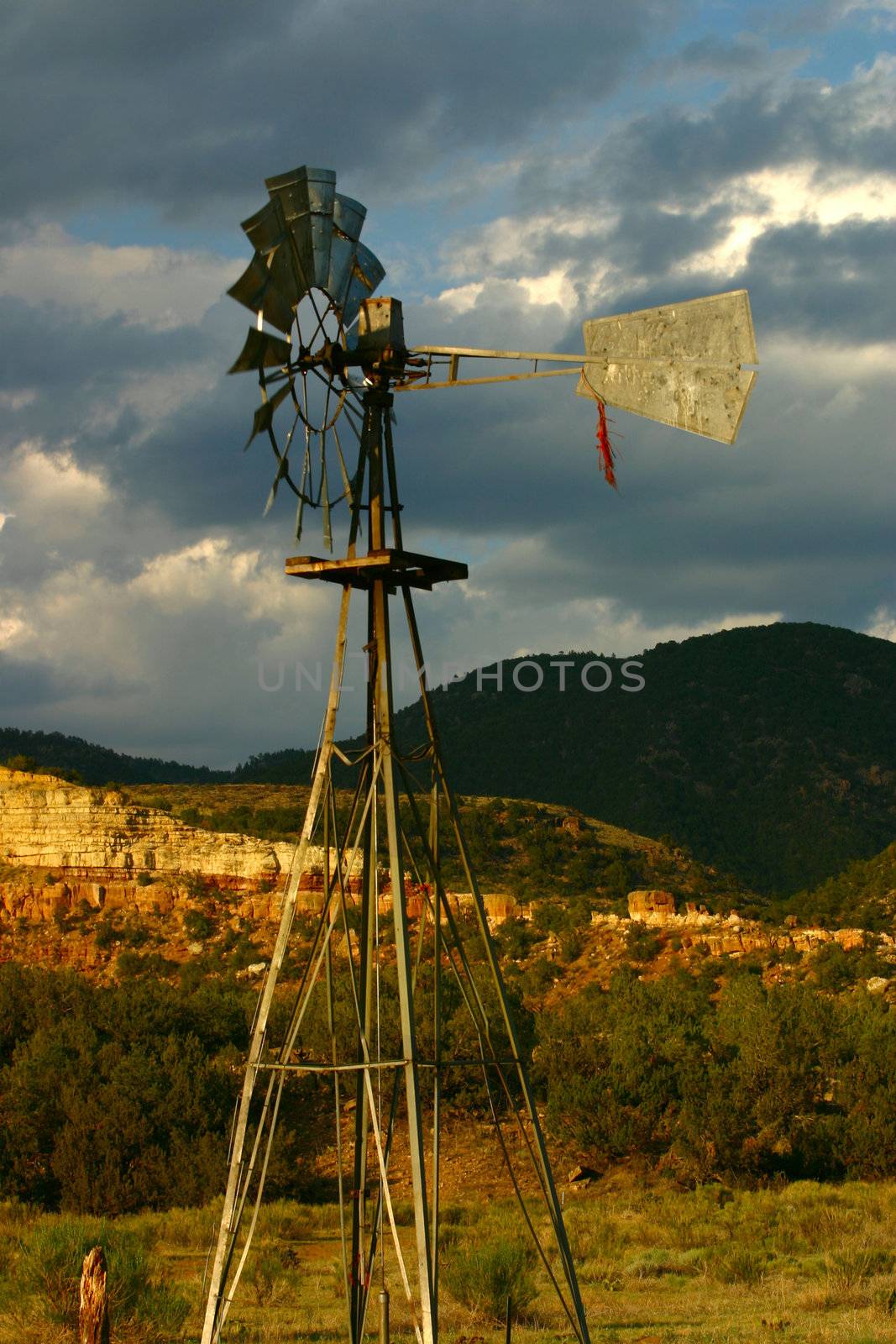 Windmill against ominous clouds in golden late evening light