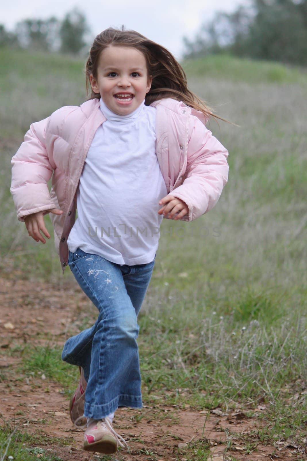 Young girl running on trail.