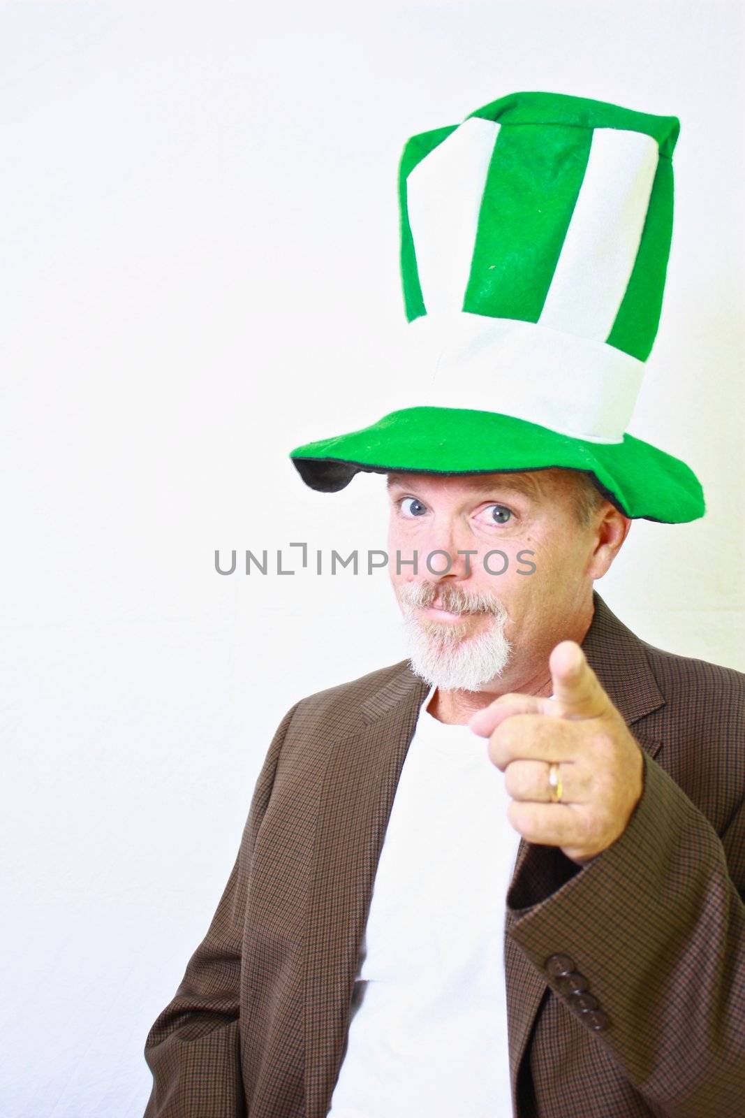 Middle aged man with tall green and white top hat pointing finger at camera.