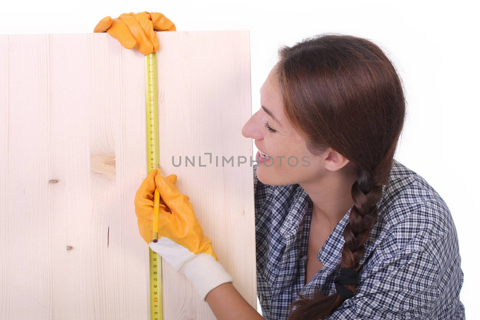 woman carpenter with wooden plank and measuring tape 