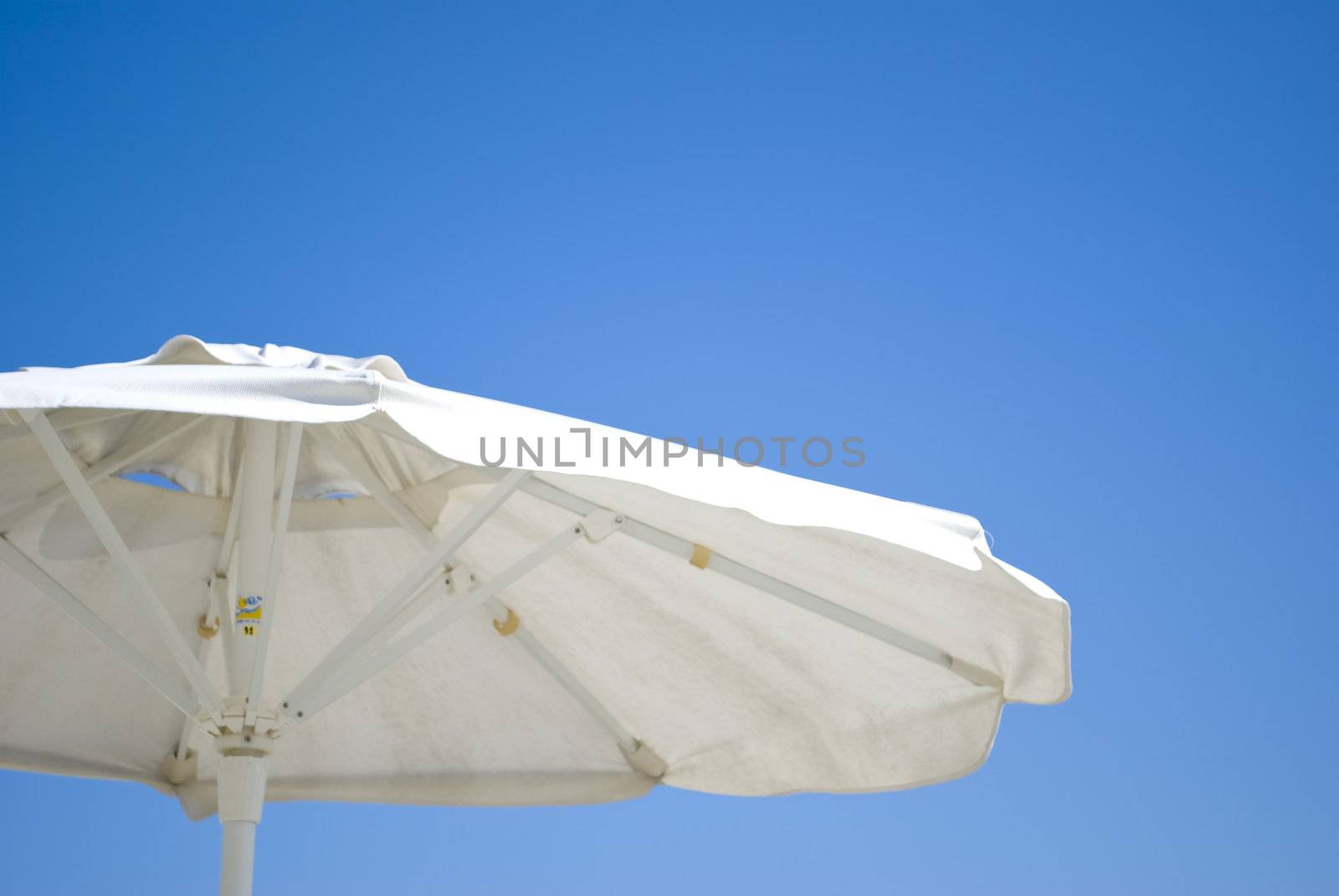 white and blue umbrellas on sunny beach