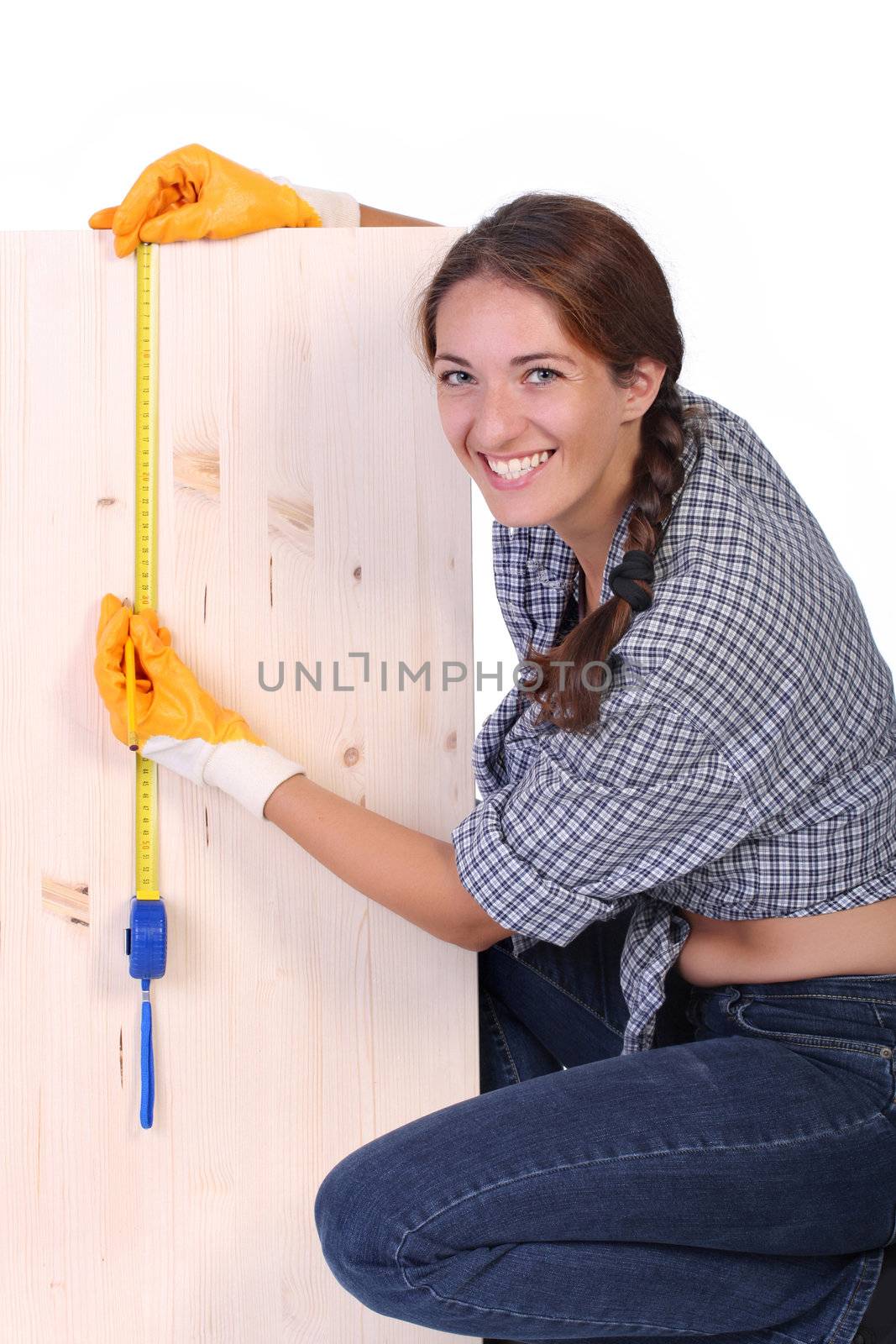 woman carpenter with wooden plank and measuring tape 