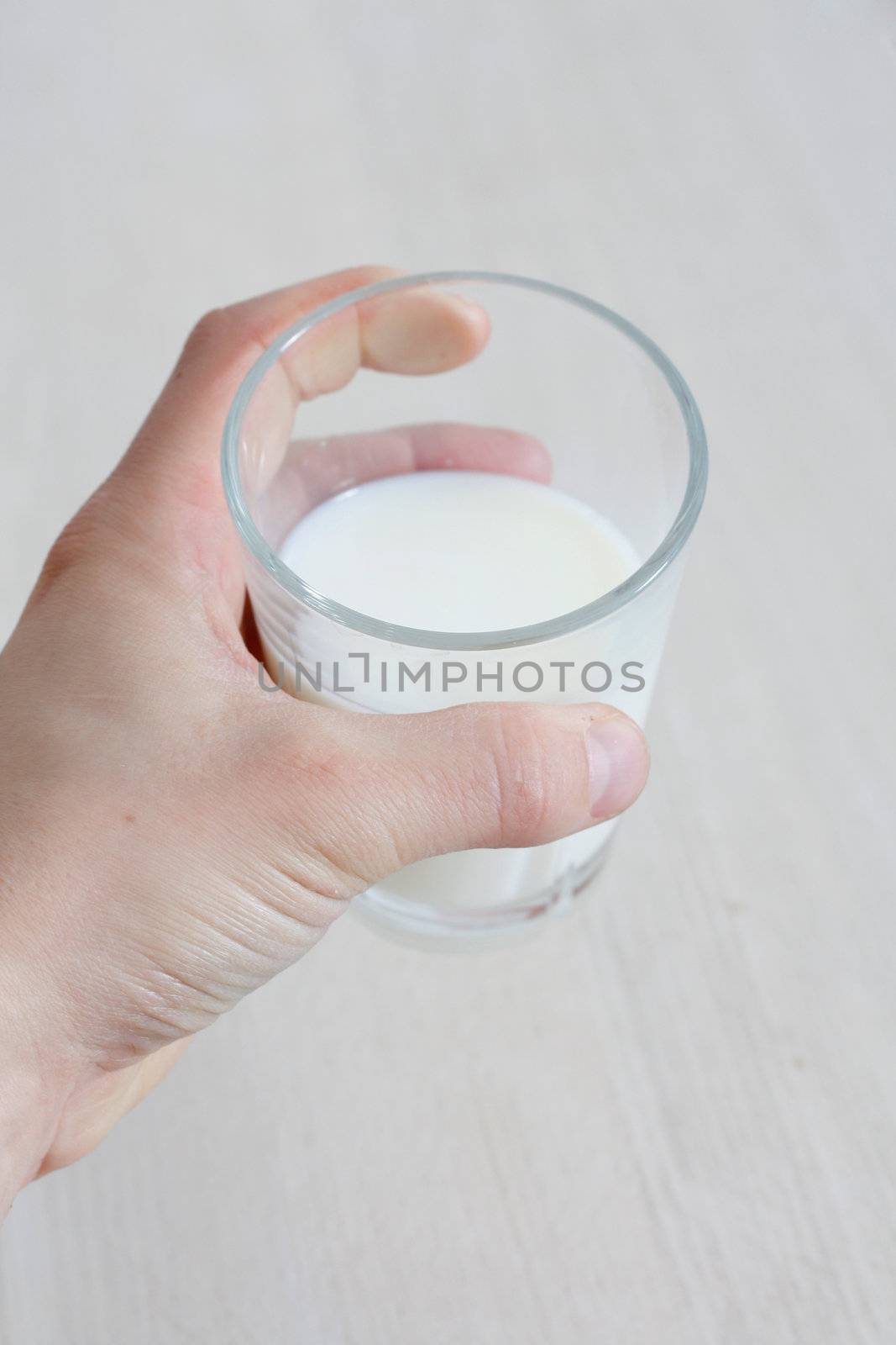 Hand holding a glass of milk