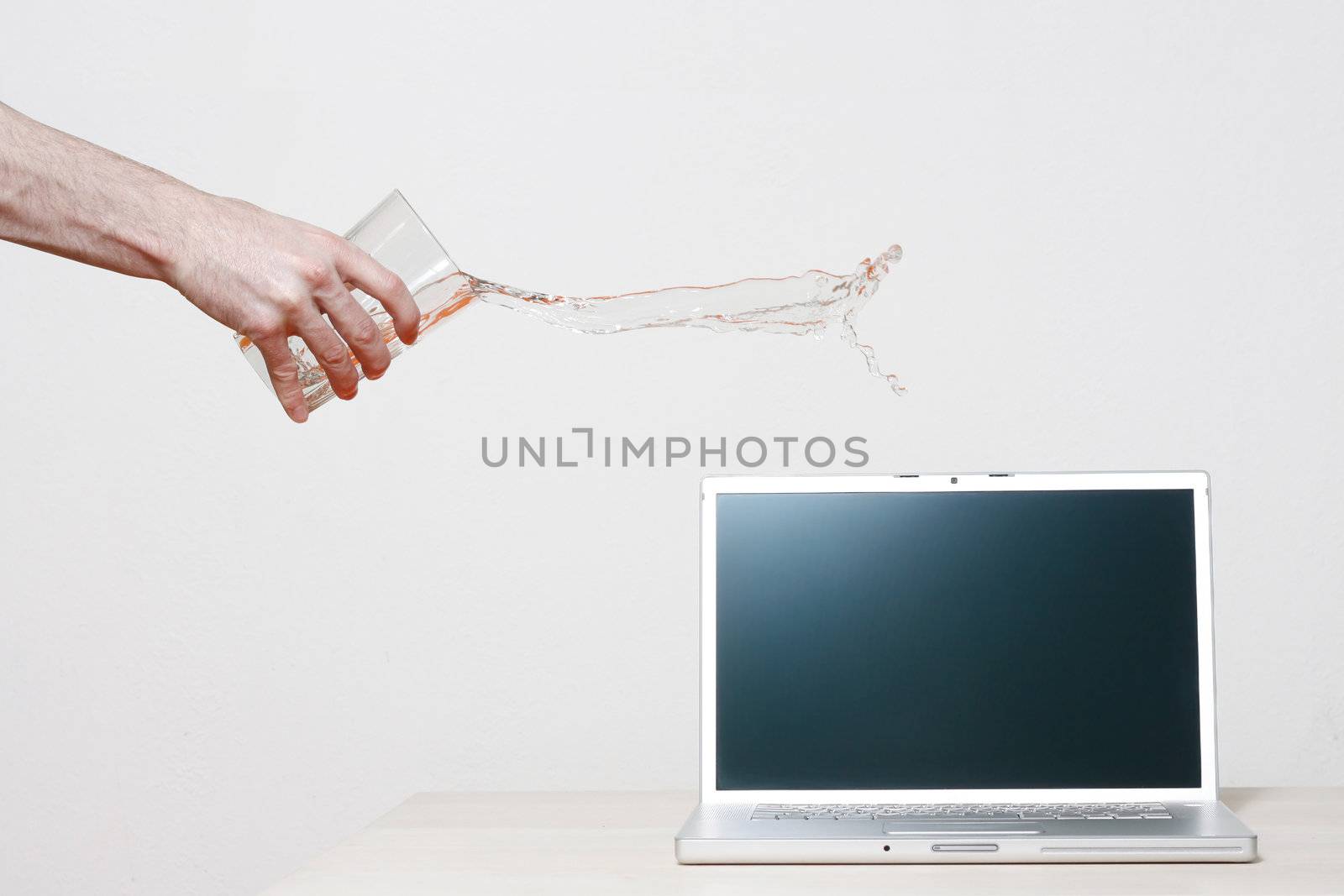 Man accidentally pouring water on laptop