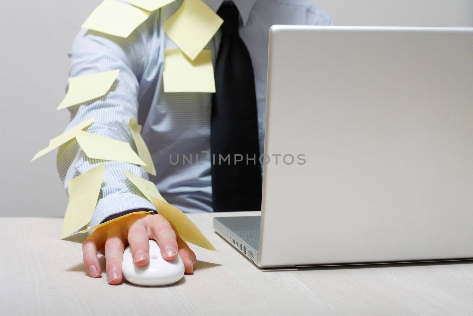A man covered in yellow notes by a laptop