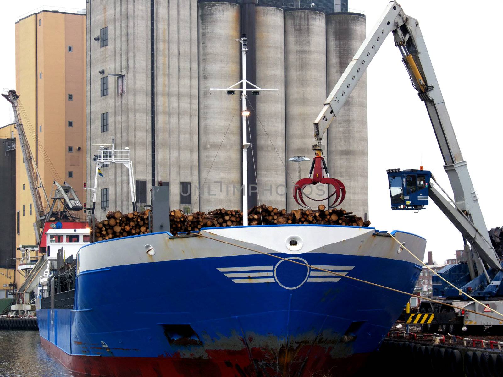 portrait of crain loading lumber on boat