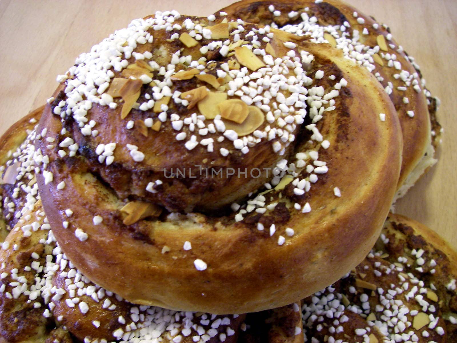 portrait of delicious pile cinnamon buns on wood plate
