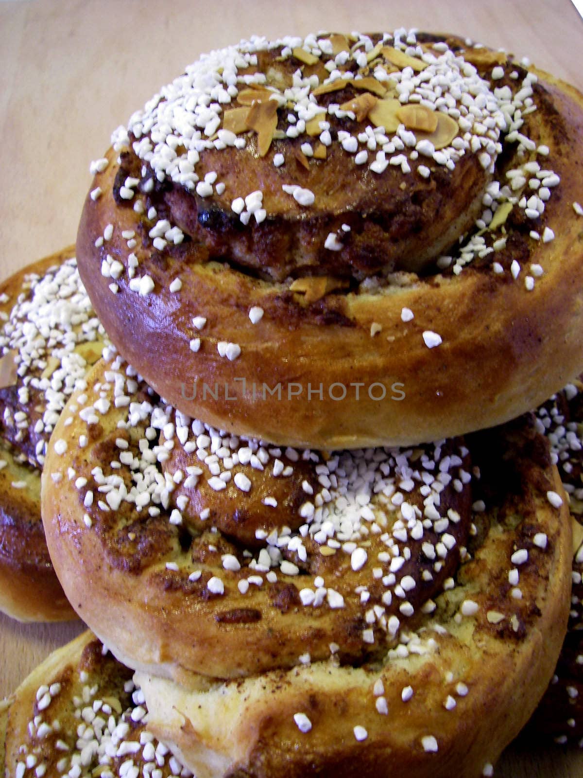 portrait of delicious pile cinnamon buns on wood plate
