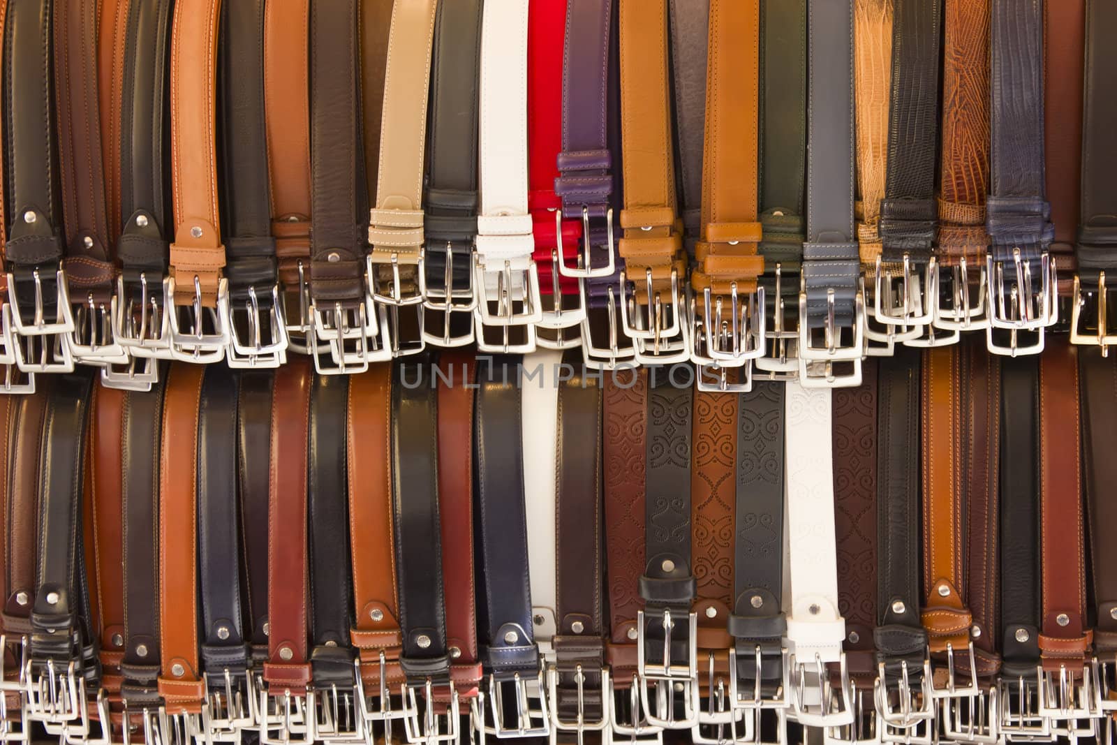 Close up of many belts sold at street market.