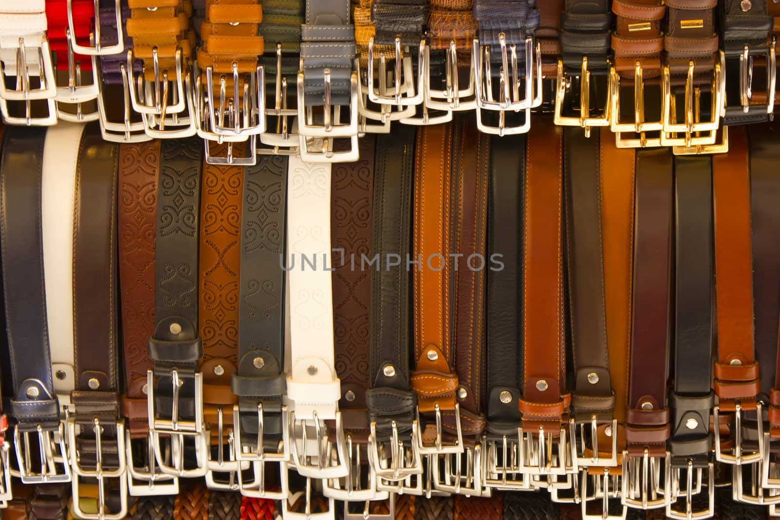 Close up of many belts sold at street market.