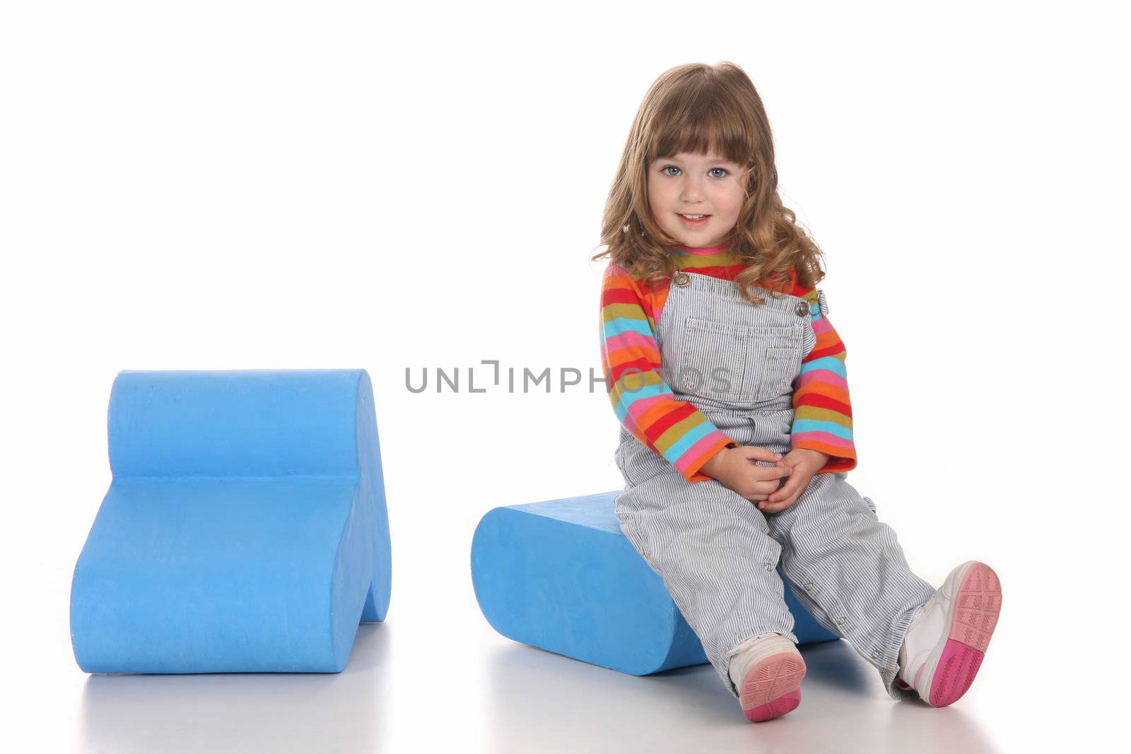 beauty a little girl sitting on blue toy box