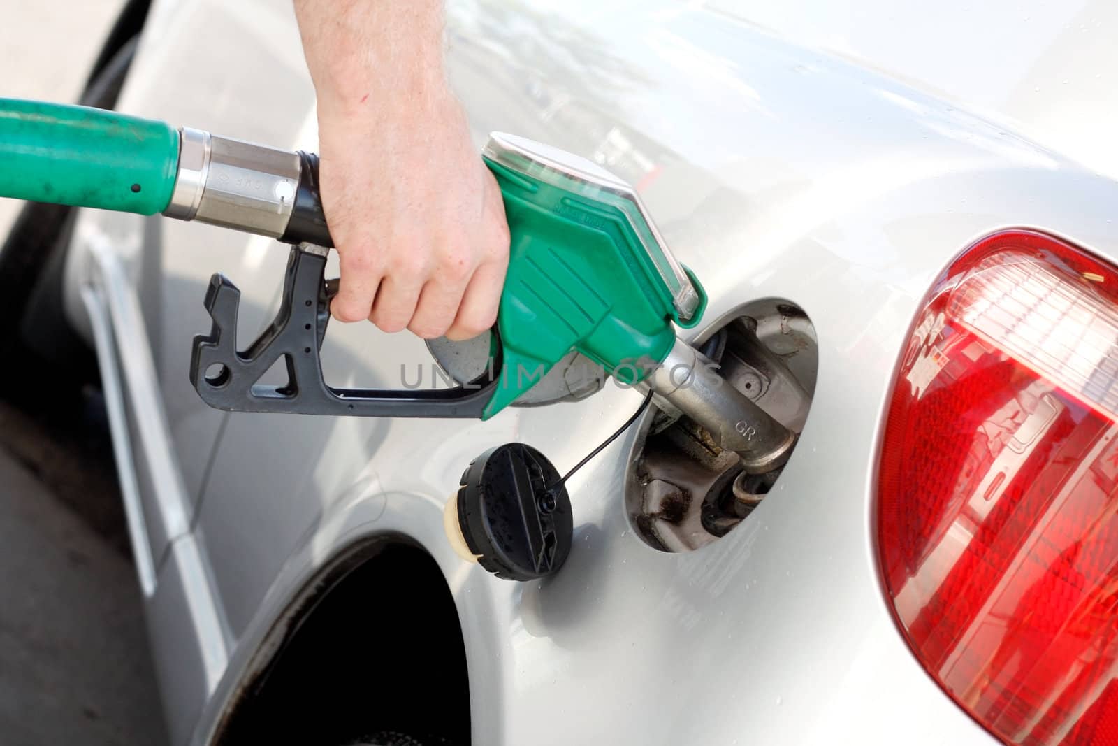 A man pumping gas in to the tank