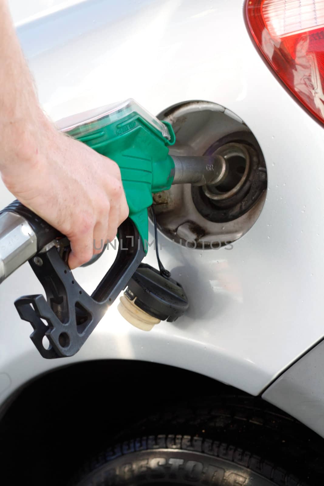 A man pumping gas in to the tank