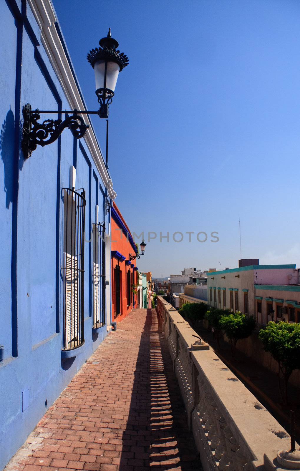 Bright blue and red houses on a tiled pathway in Mazatlan in Mexico