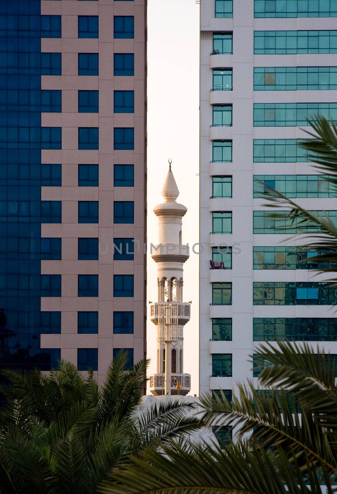 Ancient Minaret sandwiched between modern office buildings in Abu Dhabi in UAE
