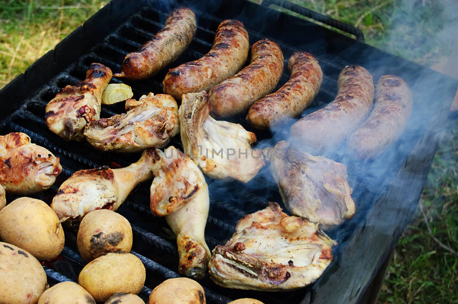 Barbecue and potato on grill preparing outdoor