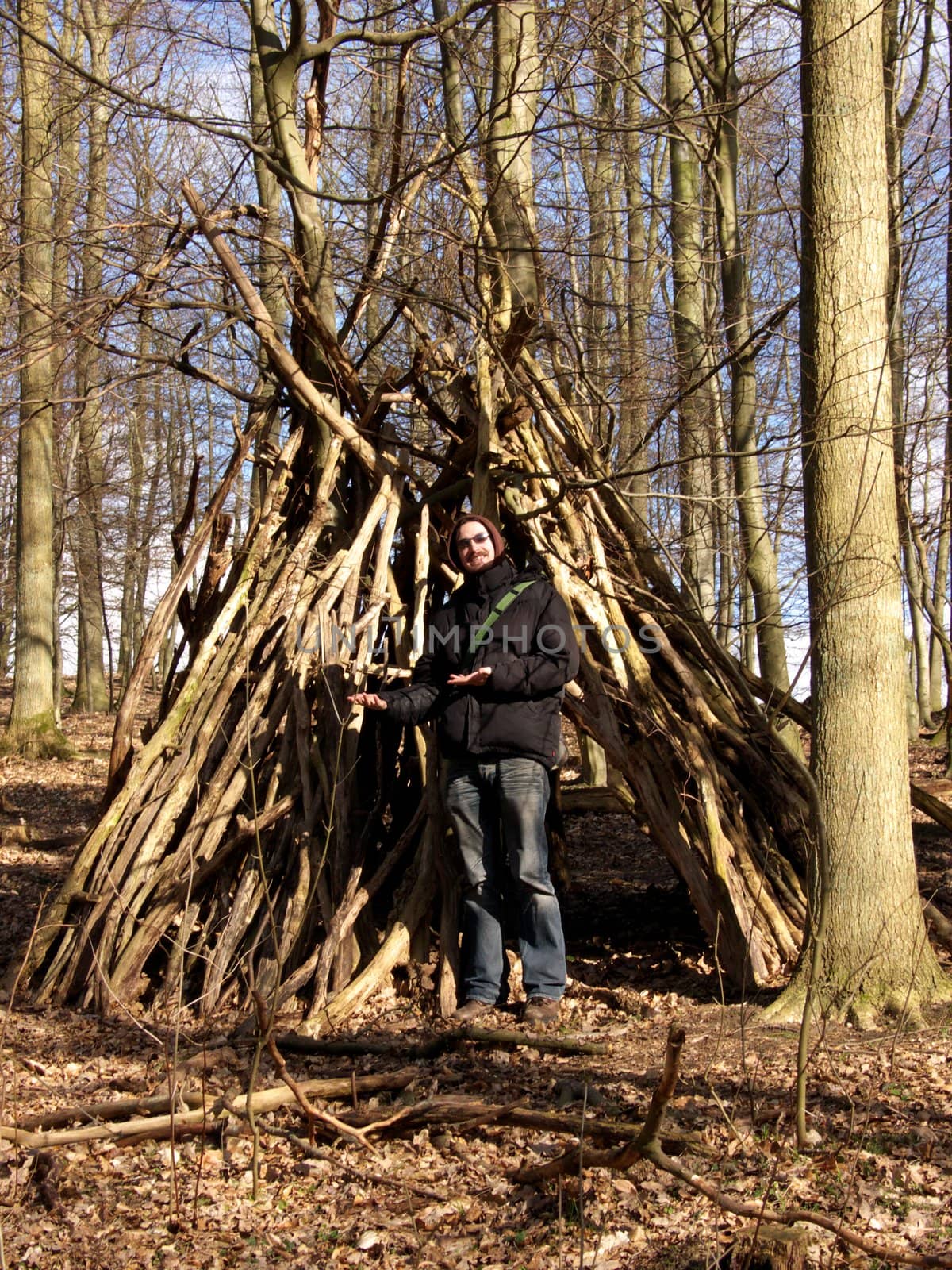 portrait of man standing infront of ancient hut