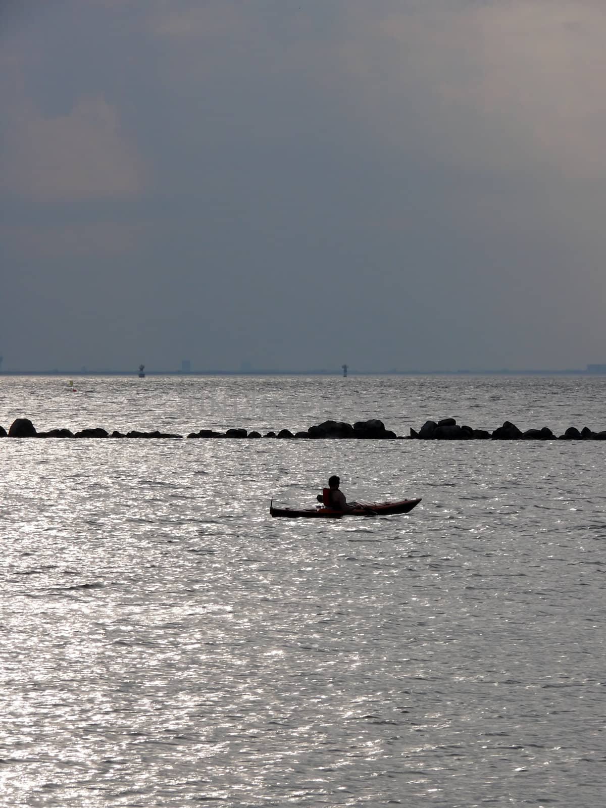 portrait of man in kayak watching ocean landscape in sunset