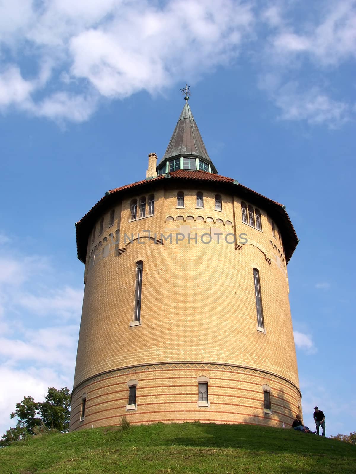 portrait of watertower on green hill in summertime