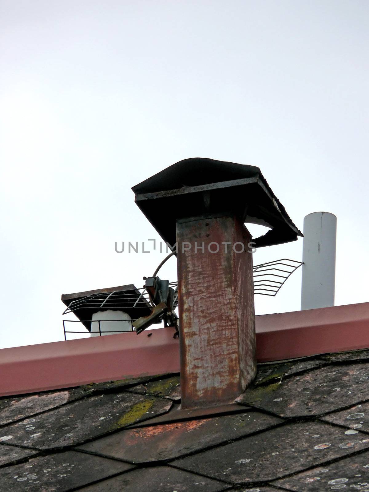 portrait of broken antenna and rusty chimney