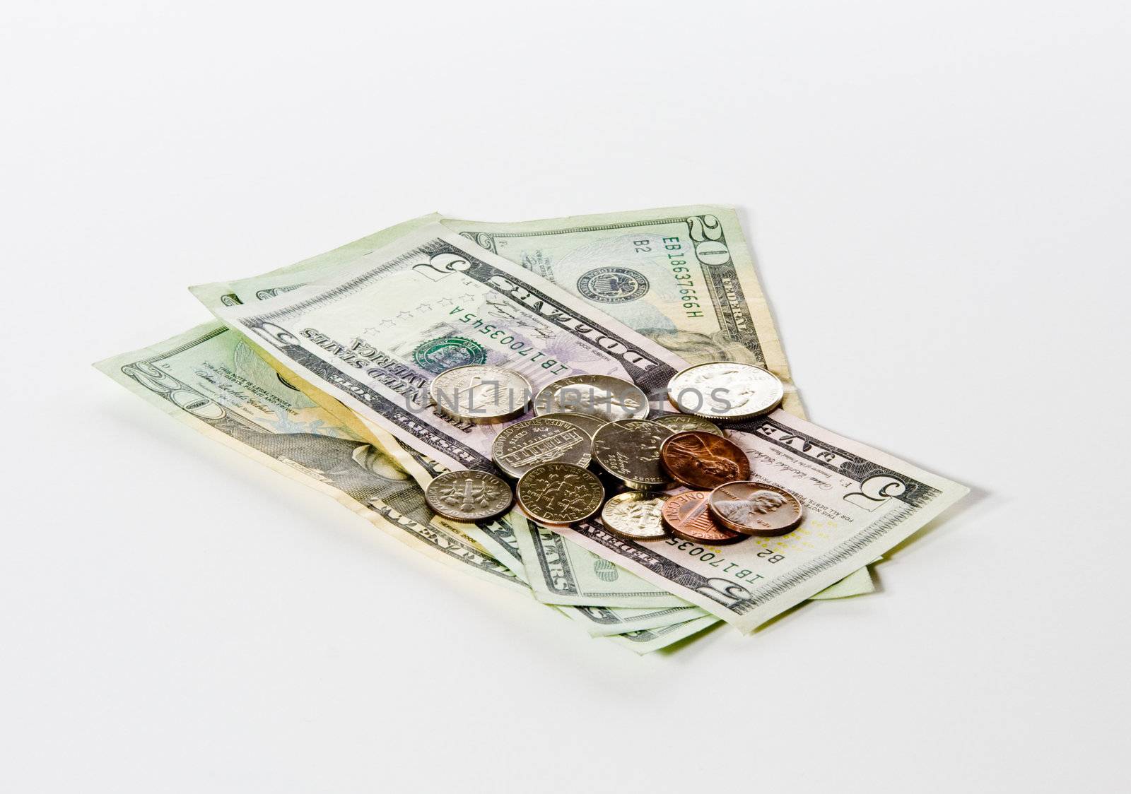 Stack of loose change on a pile of twenty and five dollar bills