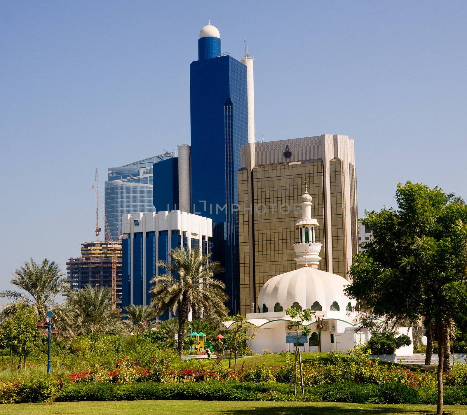 Group of office skyscrapers in Abu Dhabi with a small mosque in the foreground