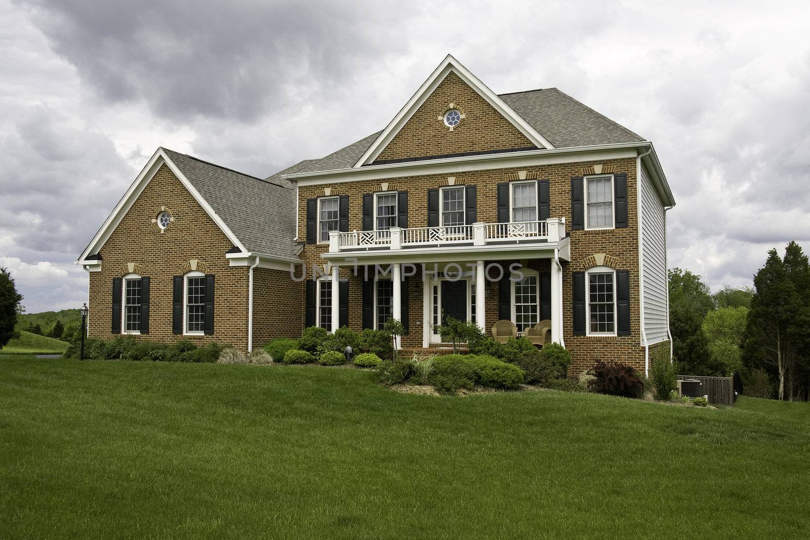 Modern House with landscaped lawn and garden on a bright but cloudy day