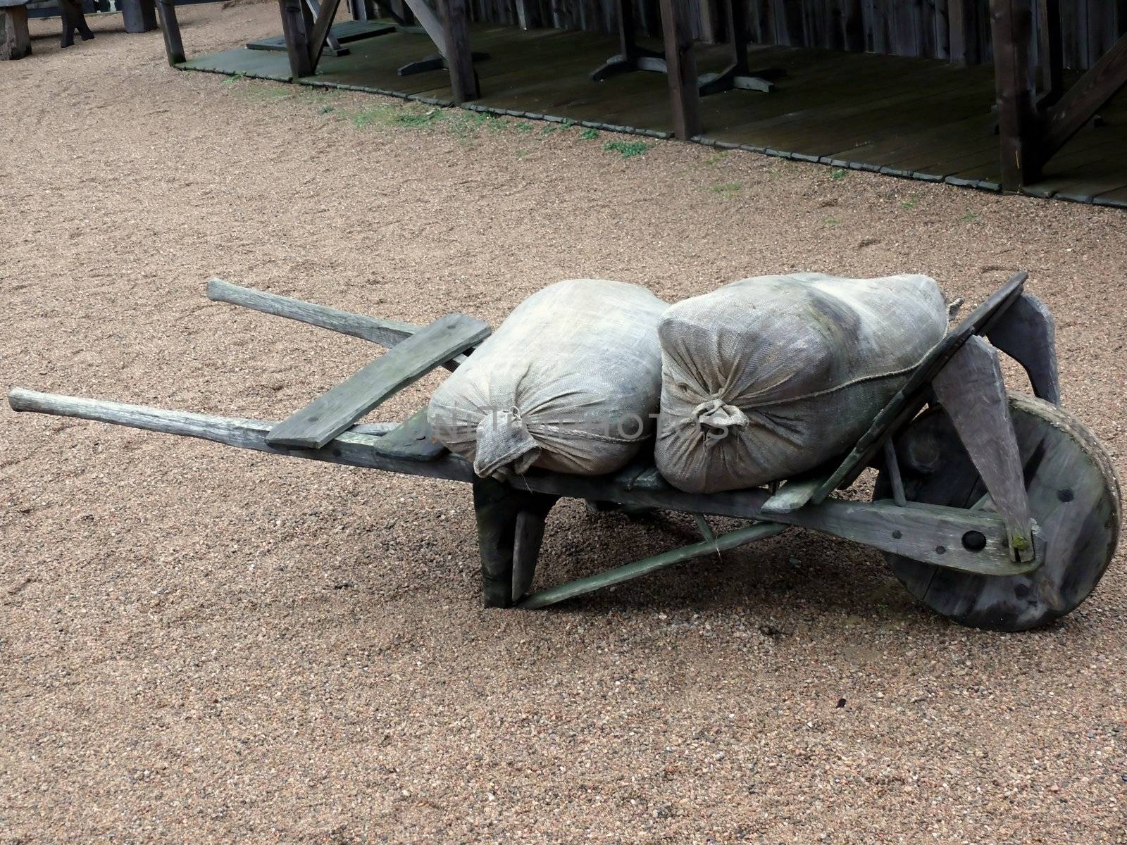 portrait of an ancient wheel barrow wih sacks