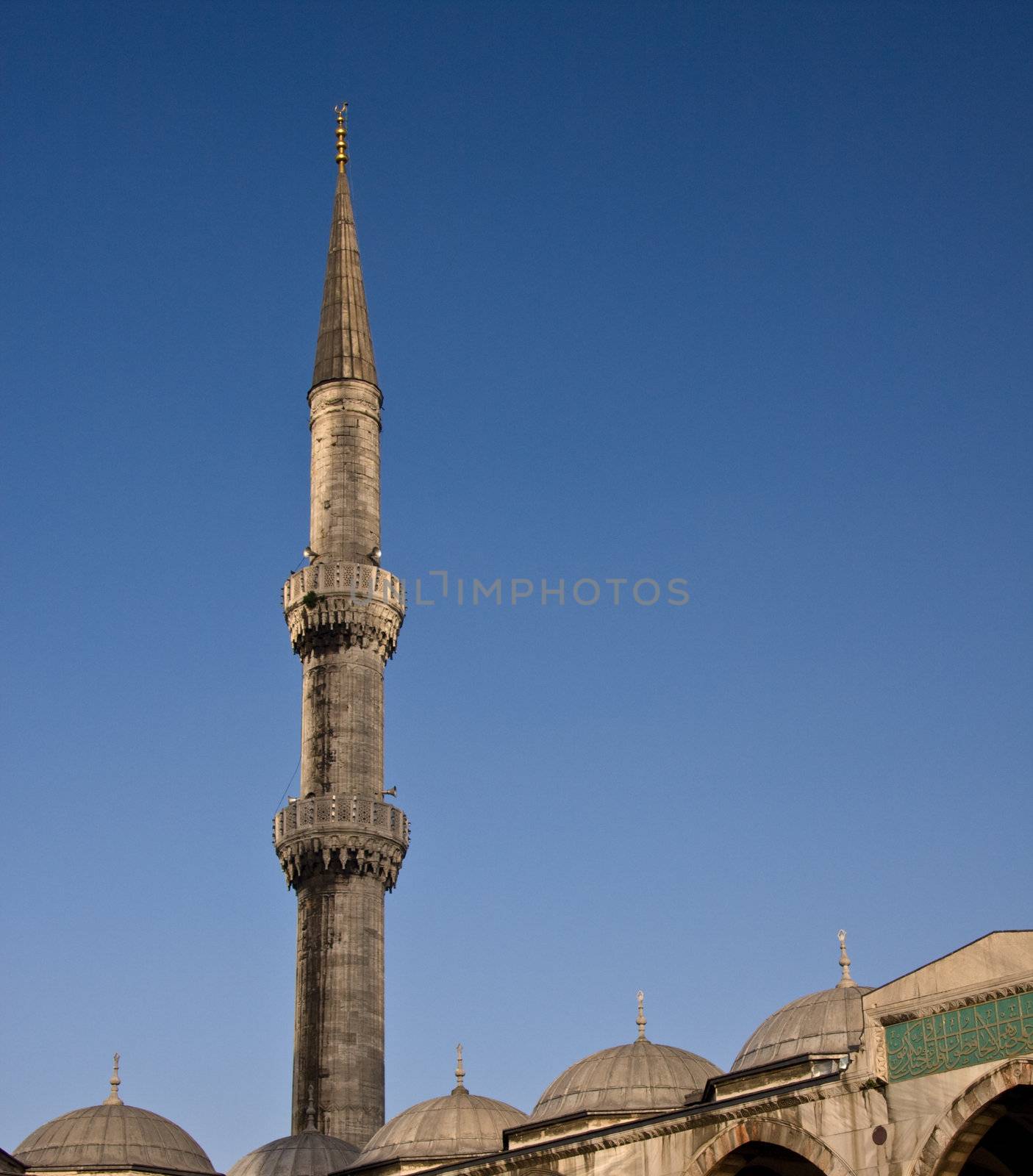 Minaret on the Blue Mosque in Istanbul against a bright blue sky