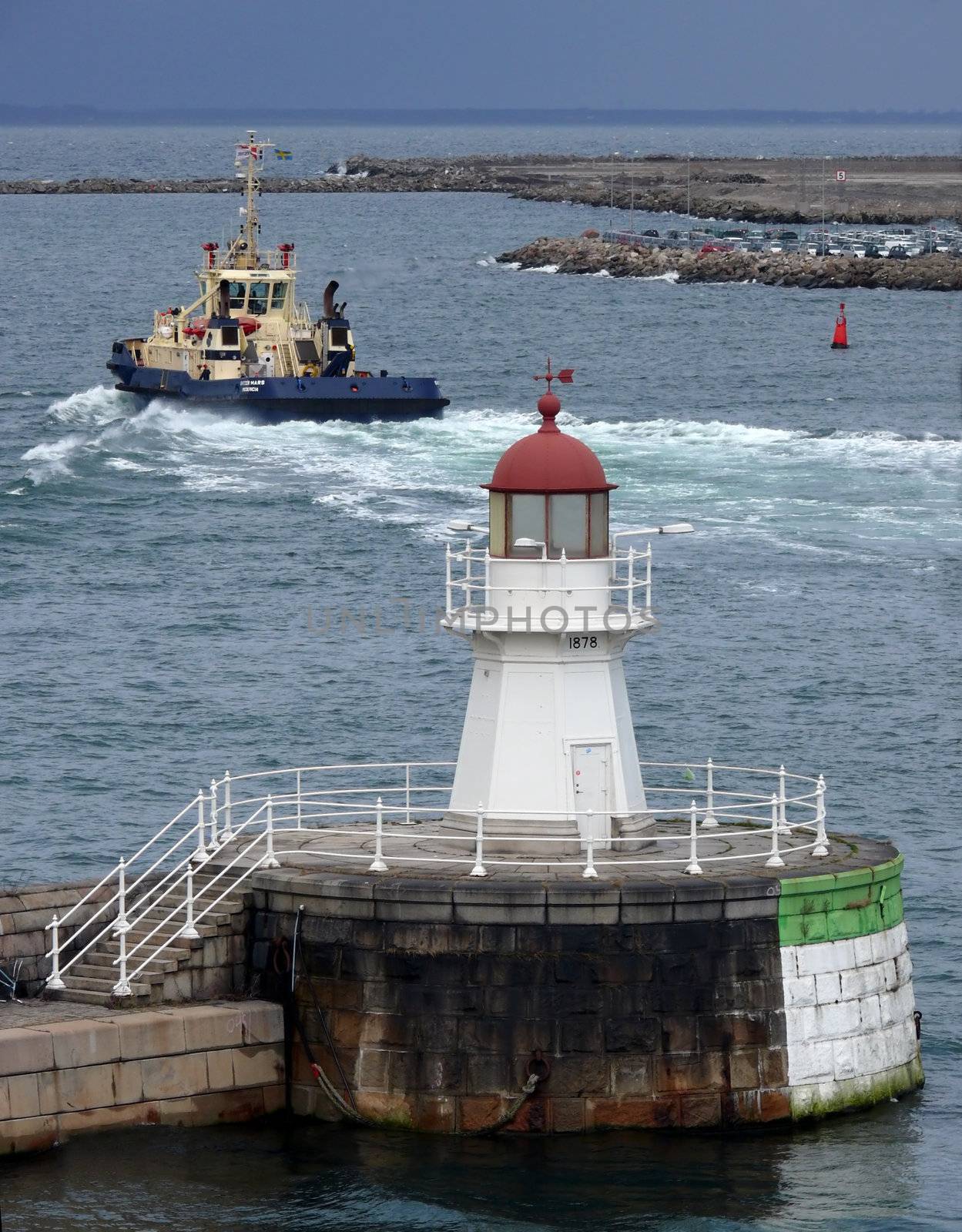 portrait of lighthouse and boat in background