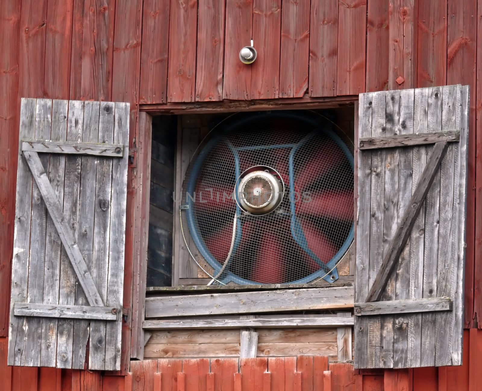 portrait of moving barn fan and open doors 