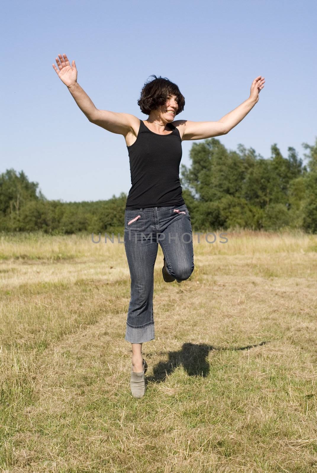 portrait of happy woman jump in countryside 