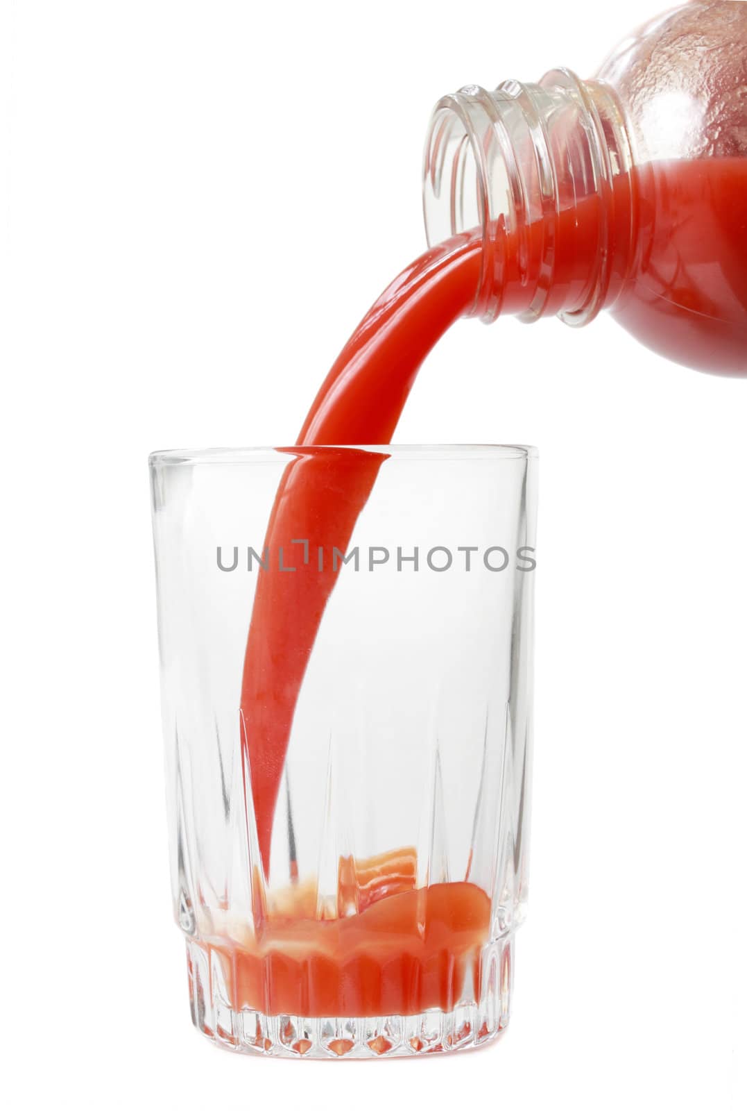 pouring tomato juice in a glass, isolated on white