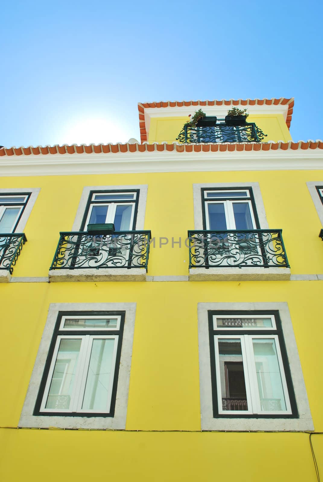 Bright sun with a traditional house building in Lisbon by luissantos84