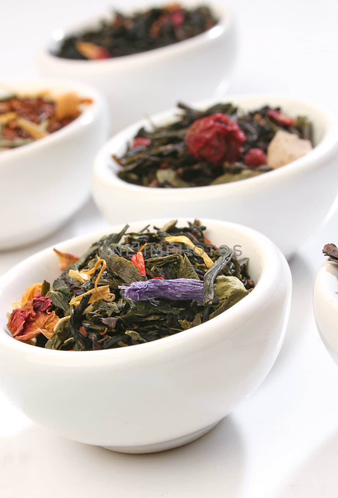Various bowls of premiun tea leaves blends, over white