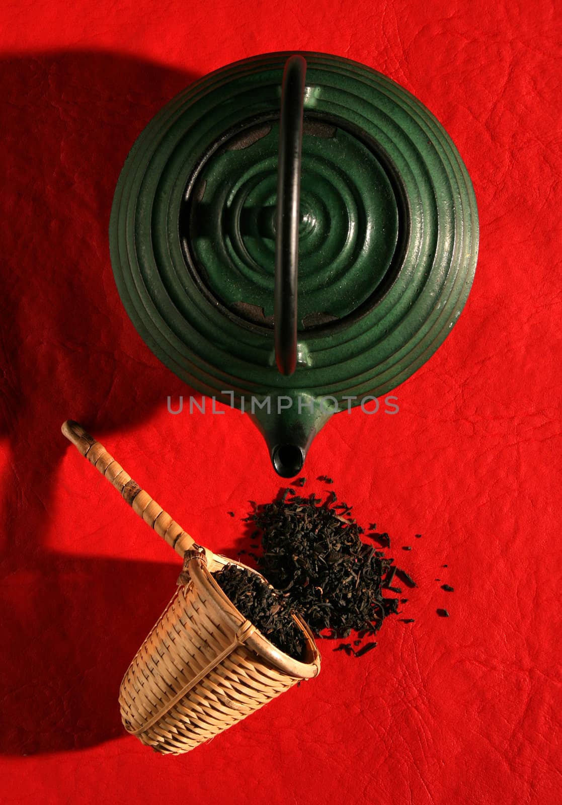 Chinese teapot and a wicker scoop with herb tea leaves by Erdosain