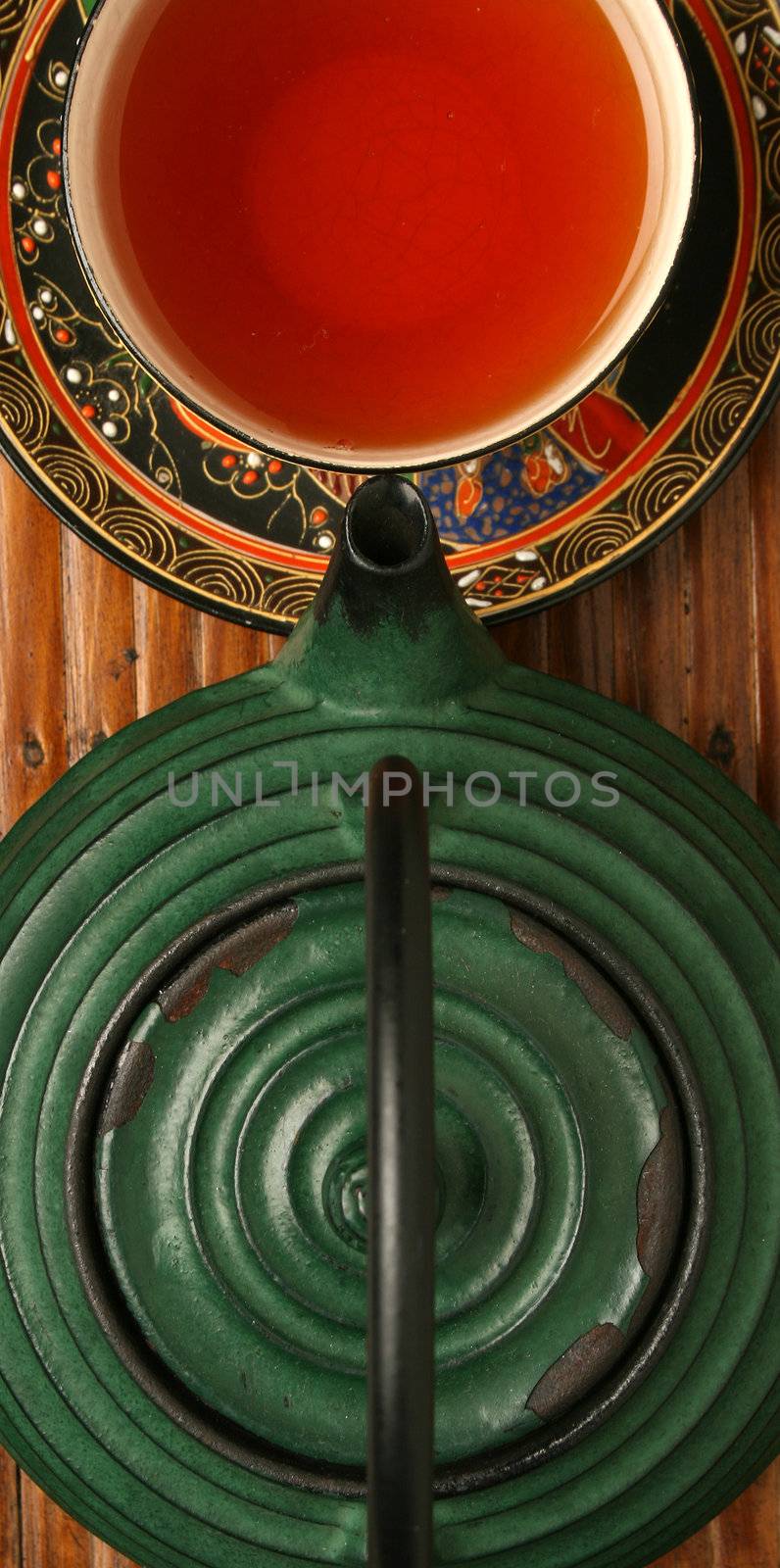 Chinese teapot and tea cup over bamboo