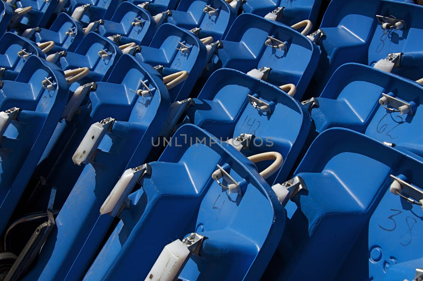 A stack of blue, plastic sleds await riders to pick them up.