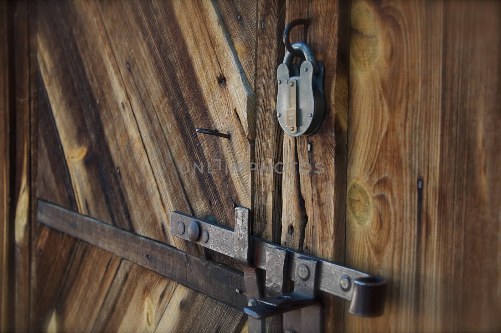 An old barn door has a metal lock and handle.