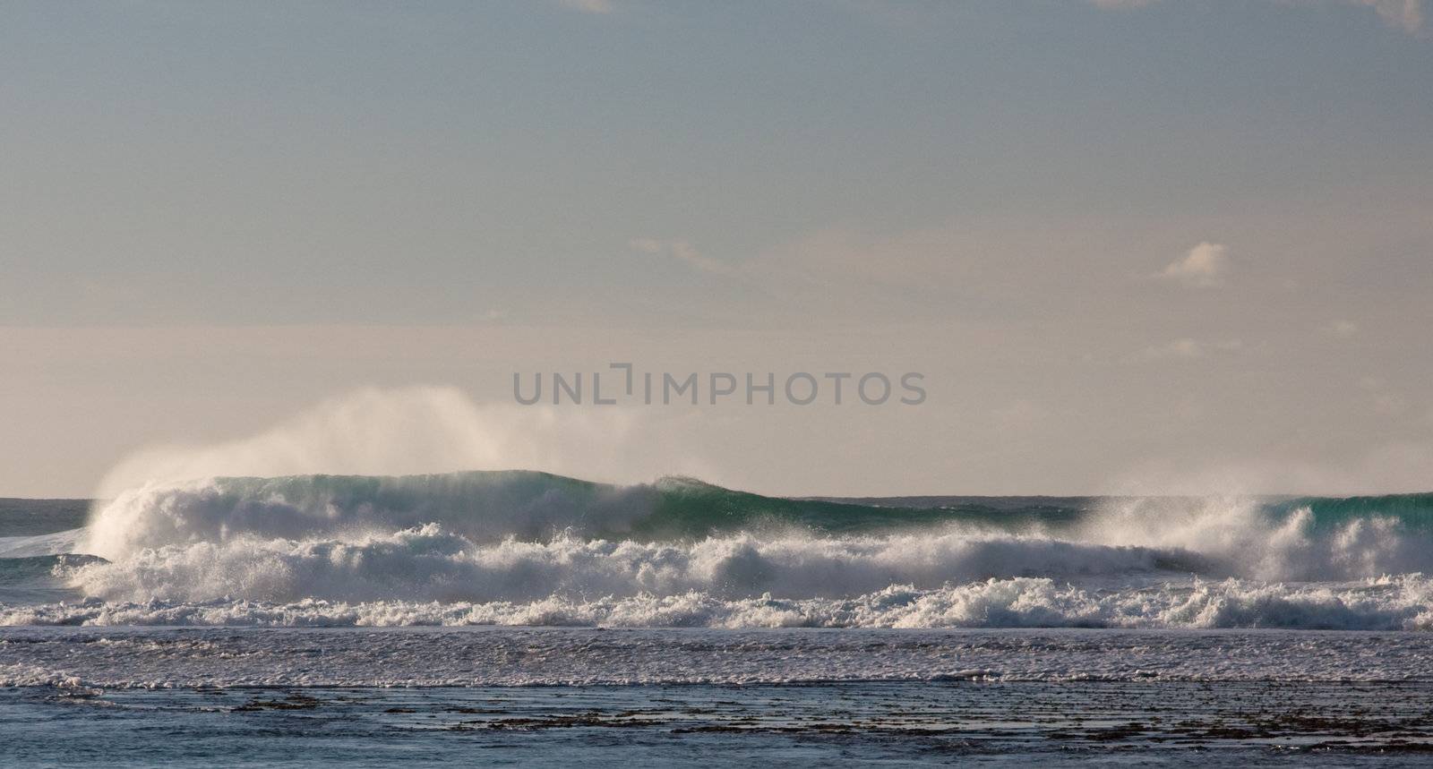 Waves breaking on the reef off a sandy beach by steheap
