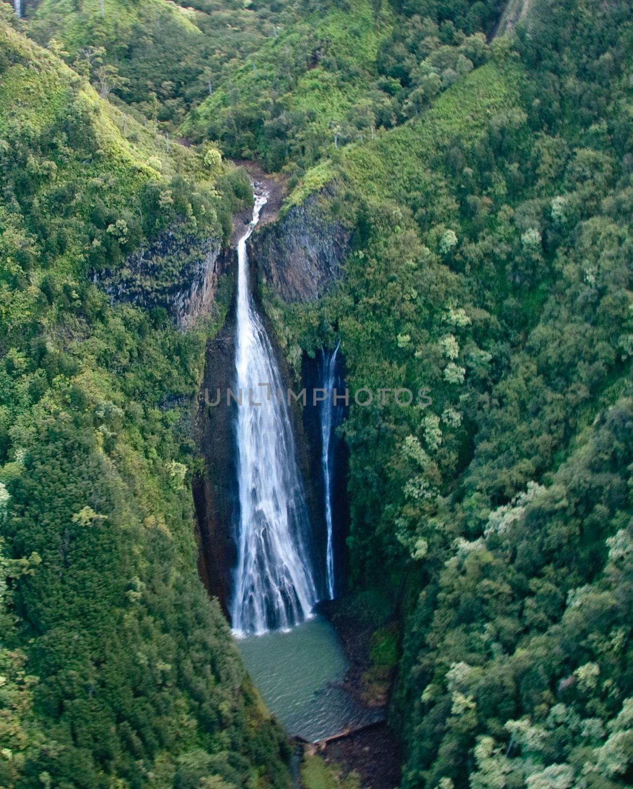 Aerial view of waterfall in mountains of Kauai by steheap