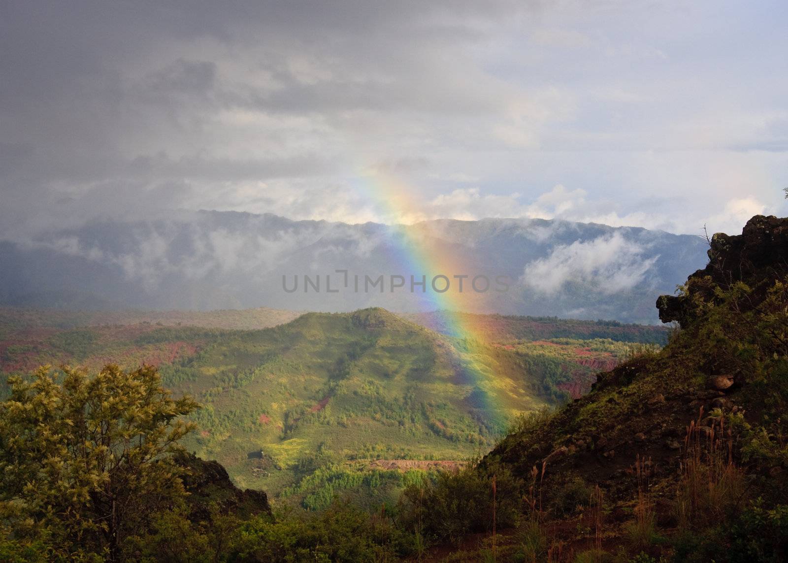 Rainbow behind craggy rocks in Waimea Canyon on Kauai