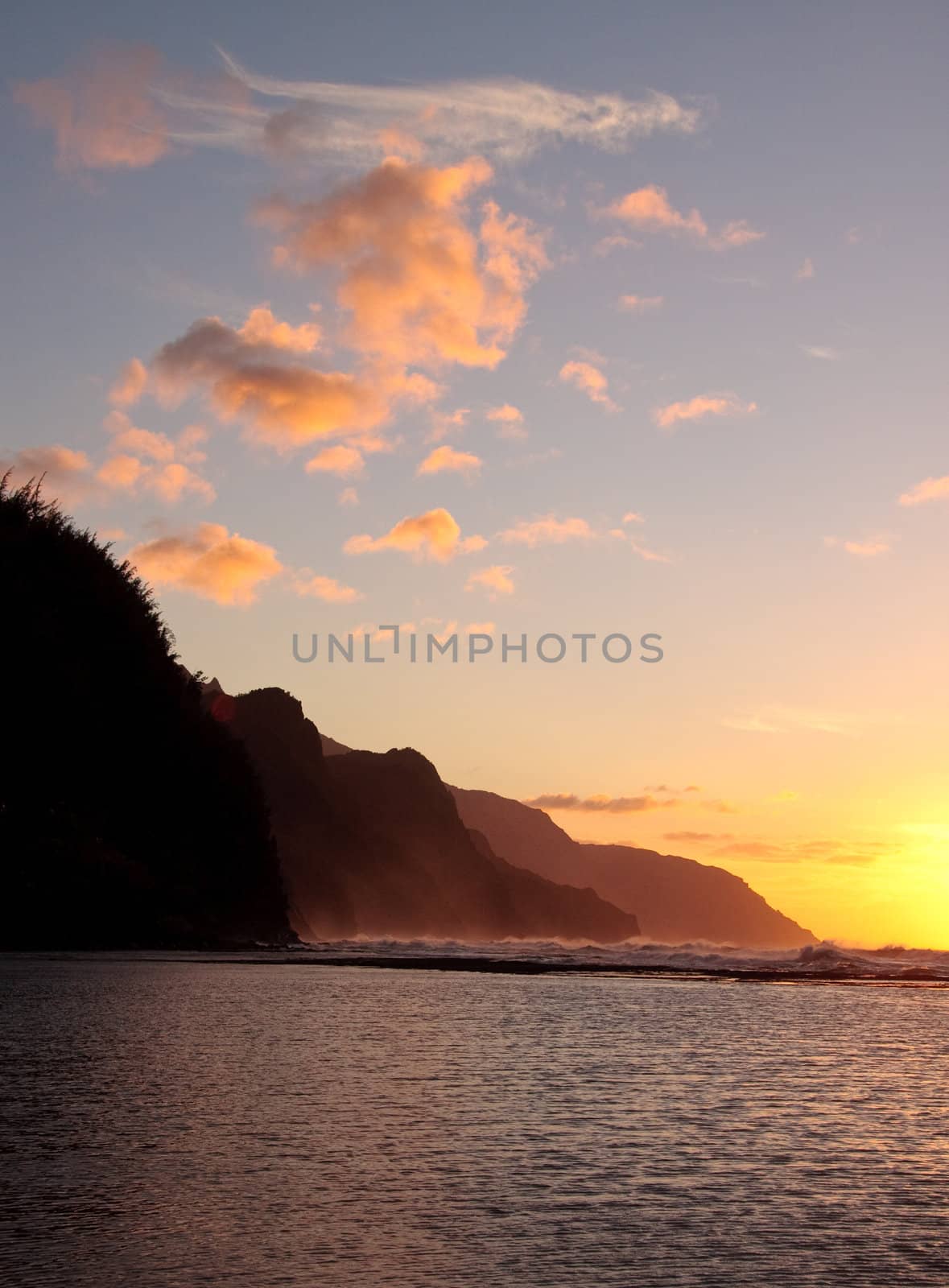 Vertical format of the headlands of the Kauai coast illuminated at sunset