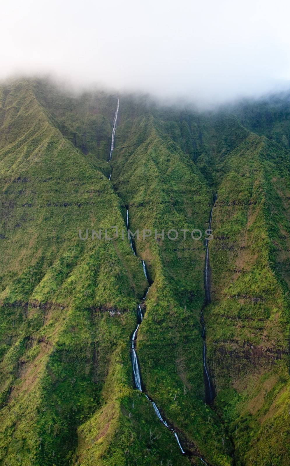 Waterfall streaming down the rock face off Mt Waialeale in Kauai in Hawaii