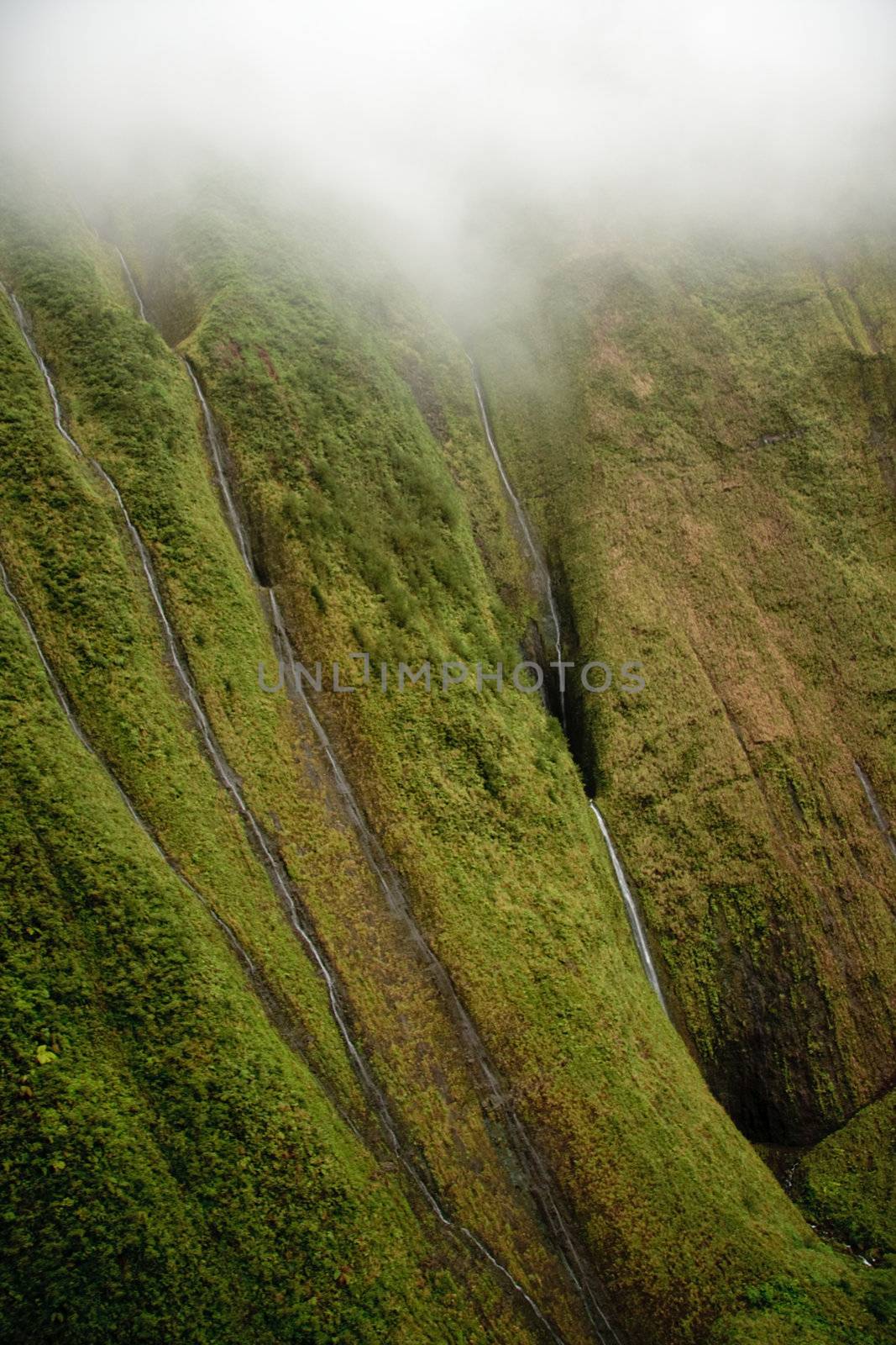 Several waterfalls streaming down the rock face in Kauai