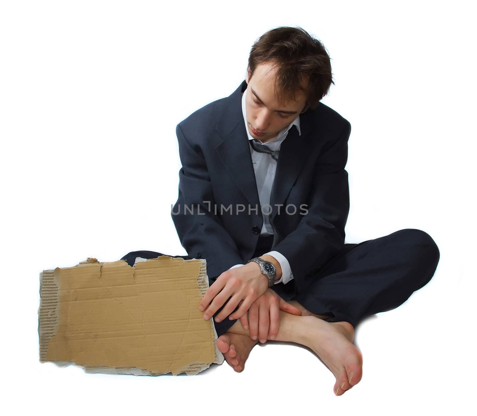 Young business man made redundant begs on the street, looking at his sign