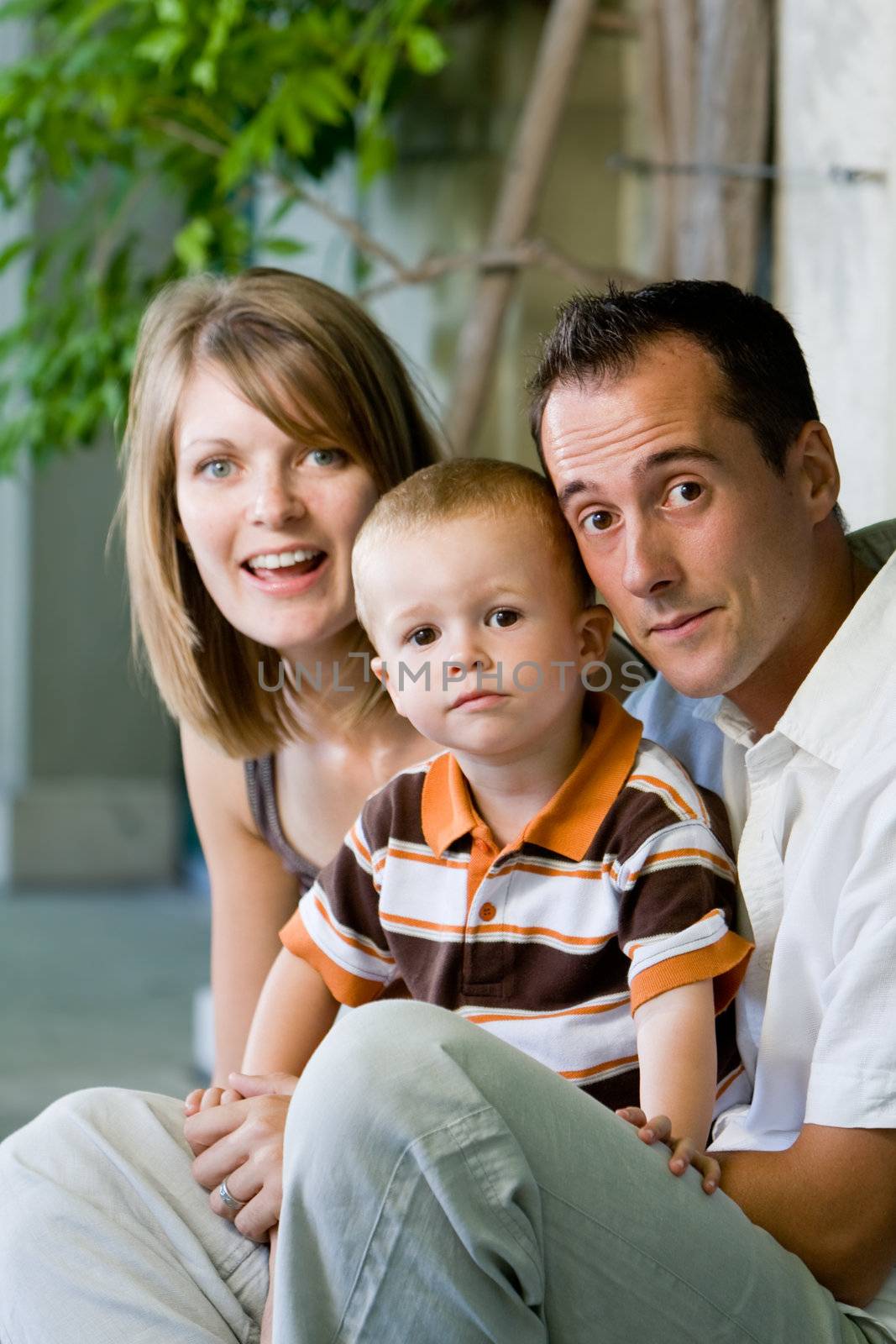 Happy perfect young family with dad, mom and son outdoors having fun