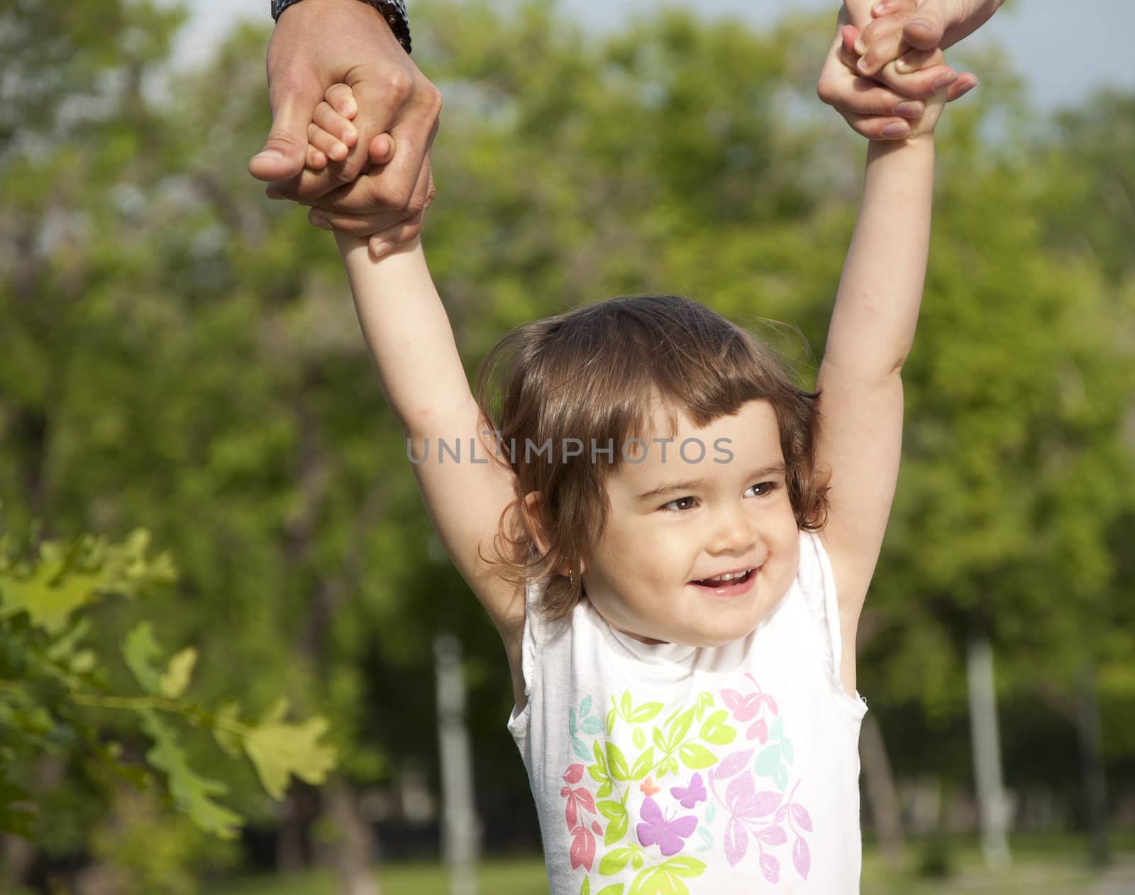 Portrait of the girl, supported by parents, walk in park